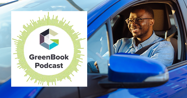 Image of a smiling male driving a blue electric vehicle with the GreenBook Podcast logo on the left