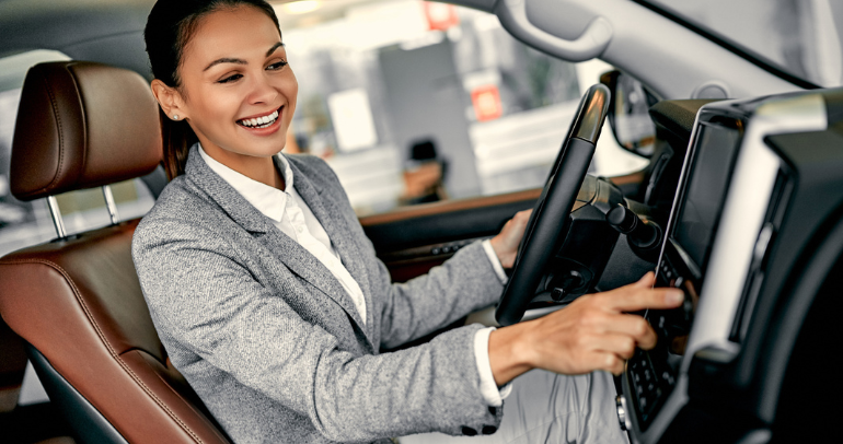 Image of a woman in her BEV interacting with the vehicle's connected features on the dashboard monitor