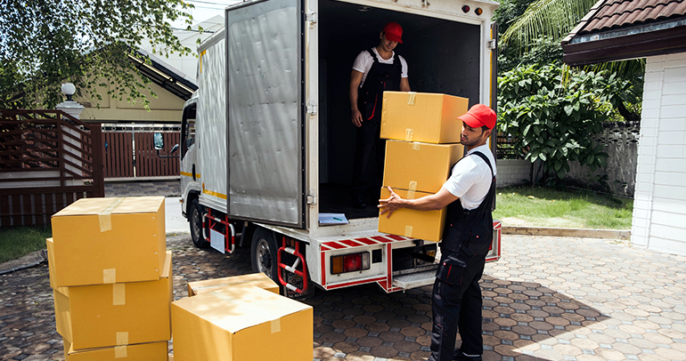 Two men unloading boxes from a commercial vehicle