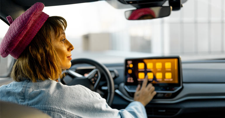 A woman driving her battery electric vehicle (BEV) around Europe using the connectivity display screen