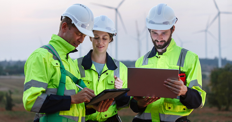 Three utility workers discussing a plan about renewable energy on site