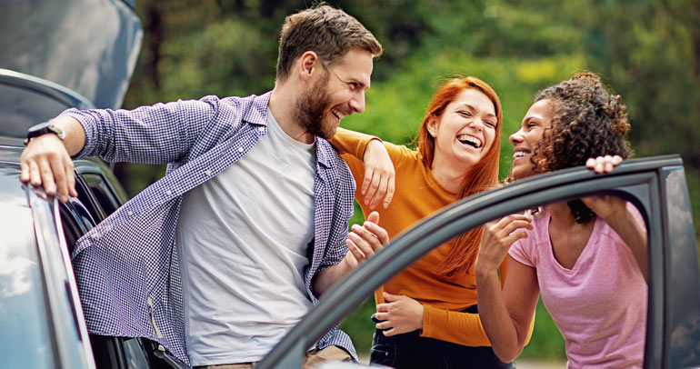 A group of people talking around a battery electric vehicle (BEV)