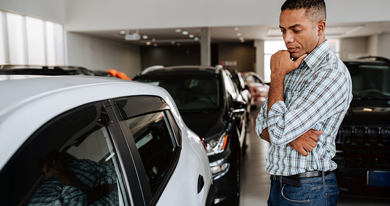 Man analyzing a battery electric vehicle (BEV) at the dealership