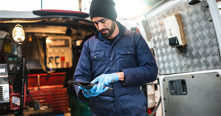 A commercial vehicle driver checking his iPad while out on the job