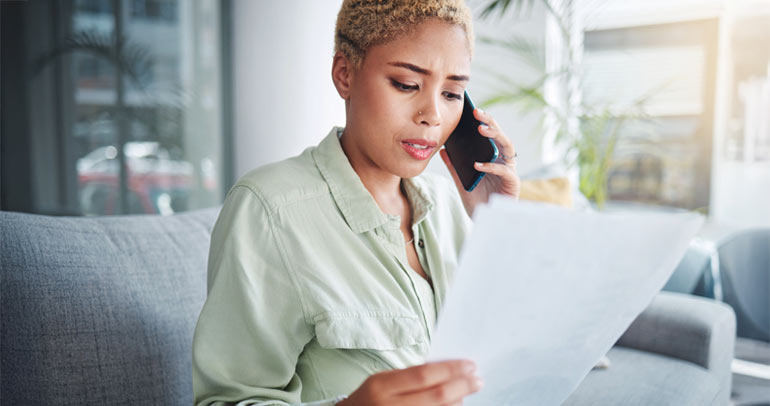 A woman on the phone with her utility customer service representative going over her energy bill