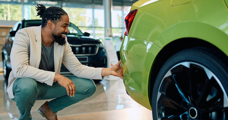A young man admiring the lime green exterior design of a BEV in a dealership