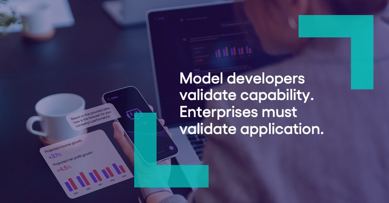A close up looking over the left shoulder of a woman who is sitting at a desk in front of a laptop with data visualizations on it and looking at the smartphone she's holding in her left hand that has design elements showing an AI robot head providing an analysis of data. There is a quote from the blog author, Escalent President Christopher Barnes, that says "Model developers validate capability. Enterprises must validate application."