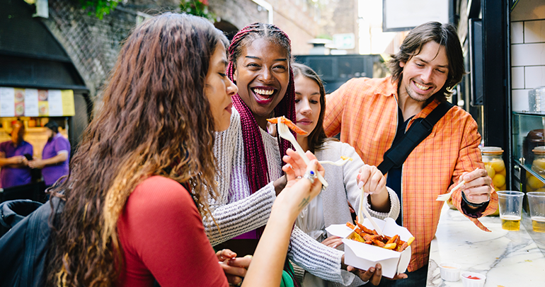 A few people eating fries in a group